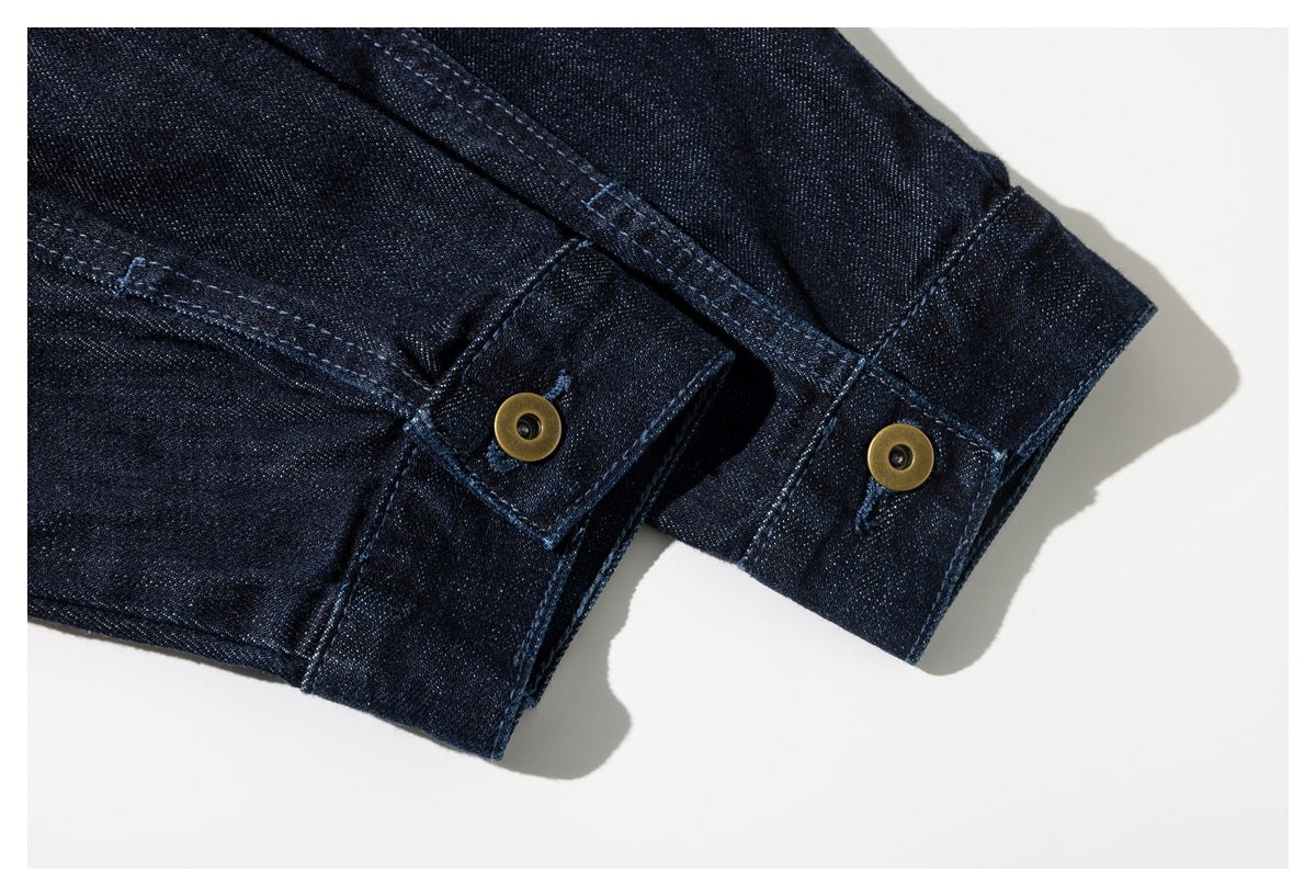 Close-up of dark indigo denim cuffs with brass-colored snap fasteners and visible topstitching.