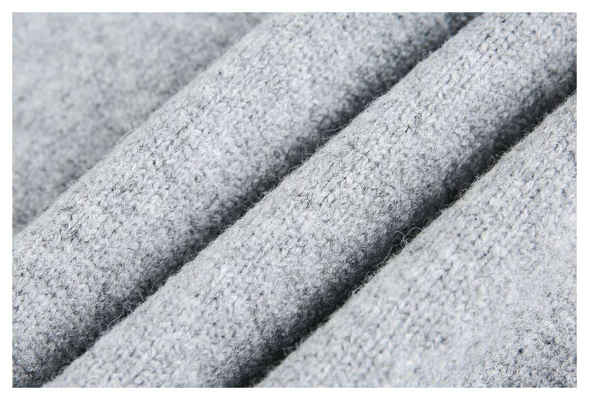 Close-up of light gray knit fabric with a fuzzy, visibly looped texture.