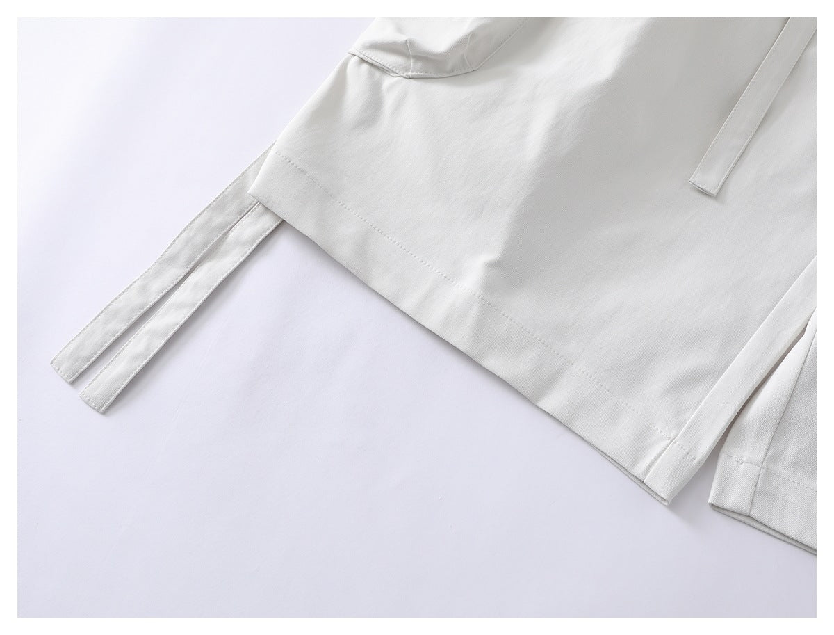 Close-up of the white shorts' hem and long side ties.