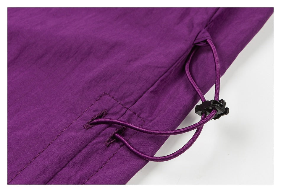 Close-up of purple pants with an adjustable elastic drawcord and black toggle.