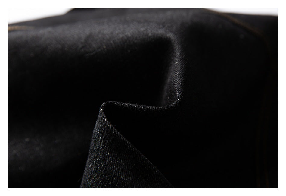 Close-up of black fabric showing its fine woven texture and folded edge.