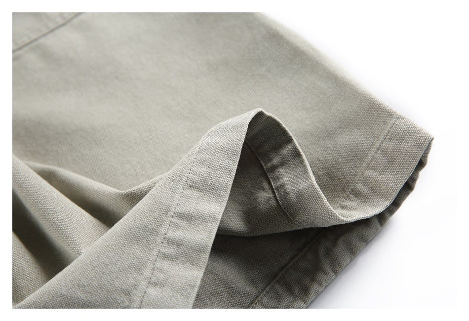 Close-up of a folded hem on light gray-beige trousers, showing the fabric texture and stitching.