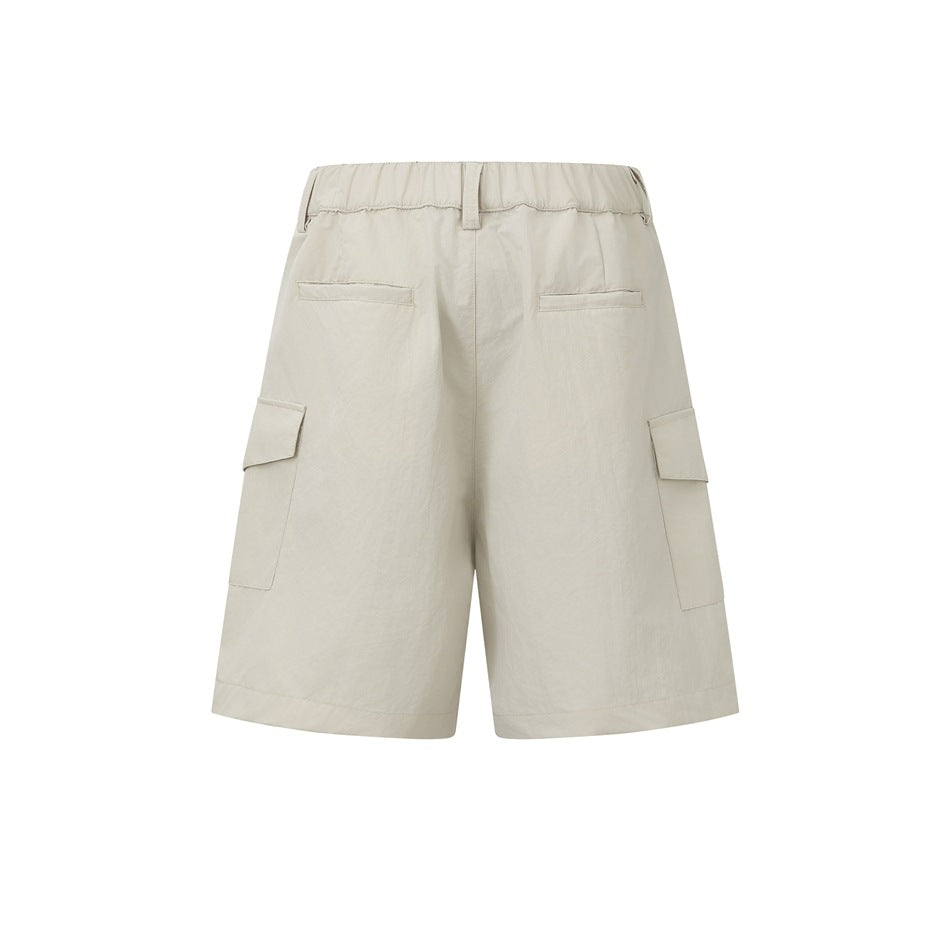 Rear view of light beige cargo shorts with an elastic waistband, belt loops, rear pockets, and flap side pockets.