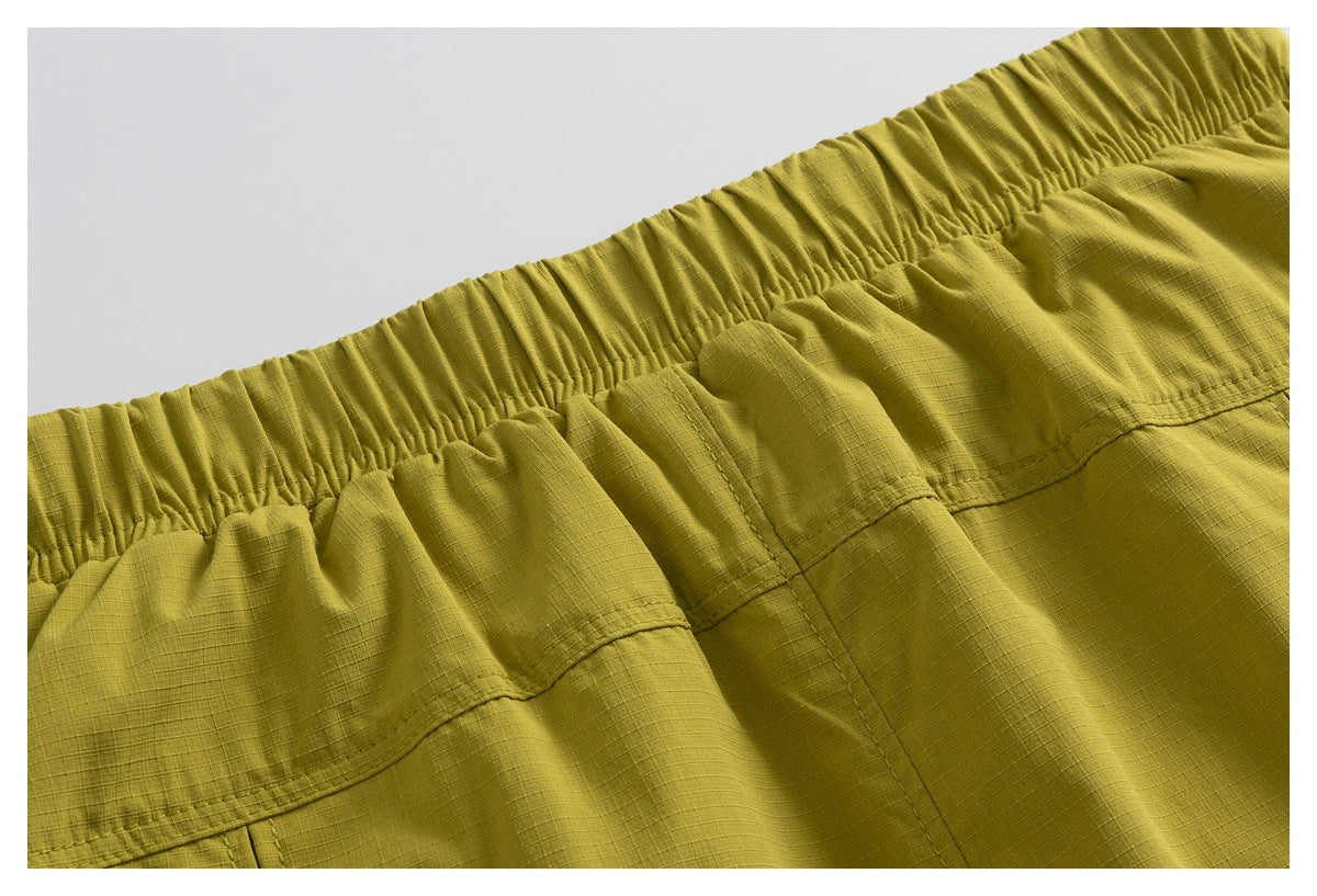 Close-up of mustard olive garment with a gathered elastic waistband and stitched seams.