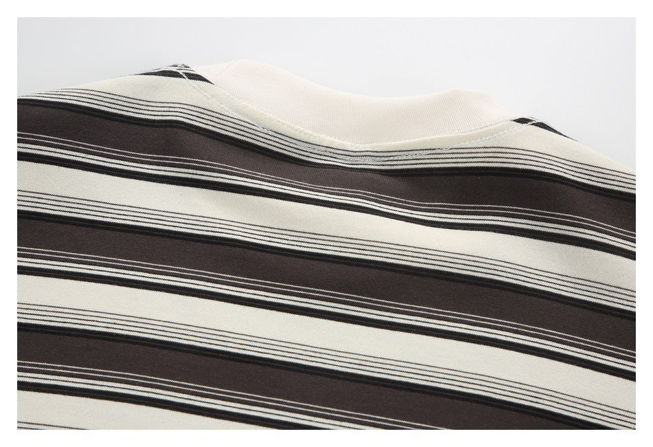 Close-up of the cream neckline and horizontal dark brown stripes on a knit garment.