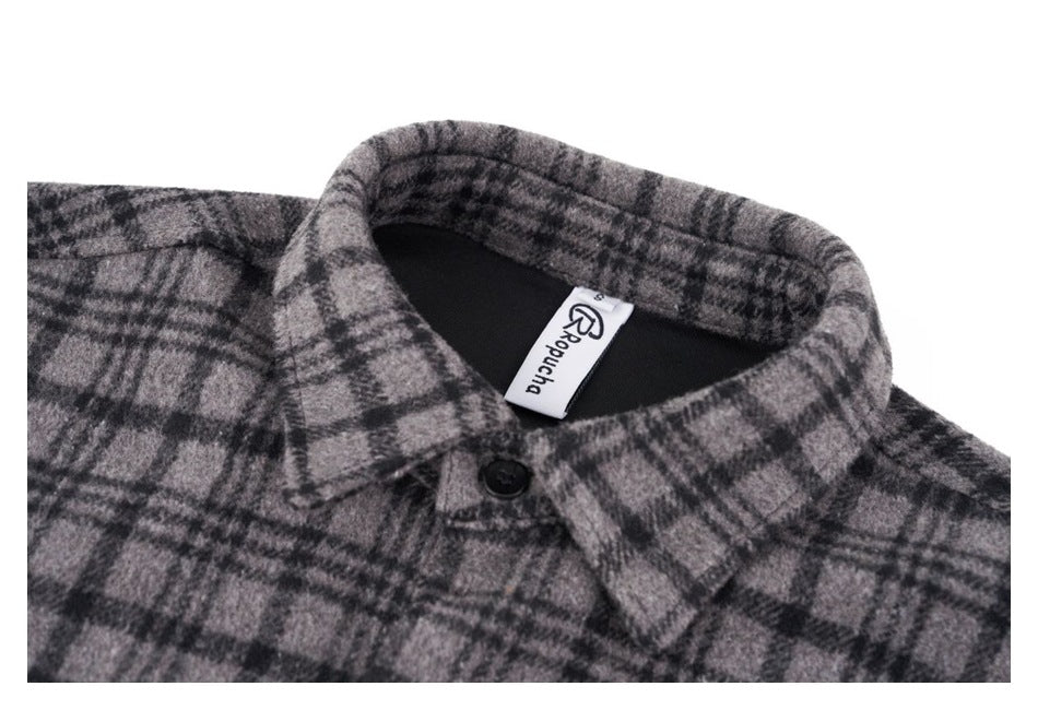 Close-up of the gray and black plaid shirt collar, black button, and neck label.