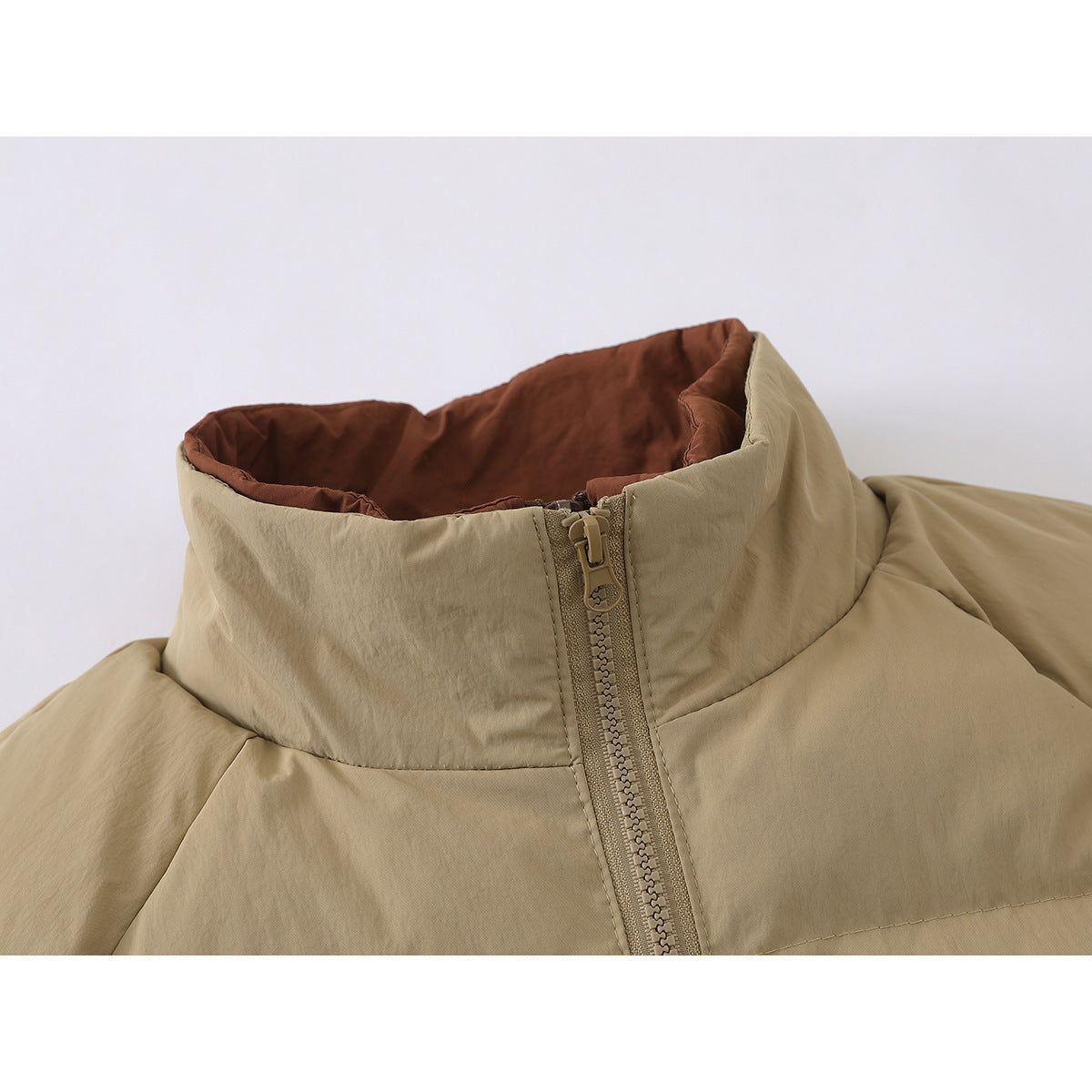 Close-up of a tan padded jacket's high collar, brown lining, and front zipper.