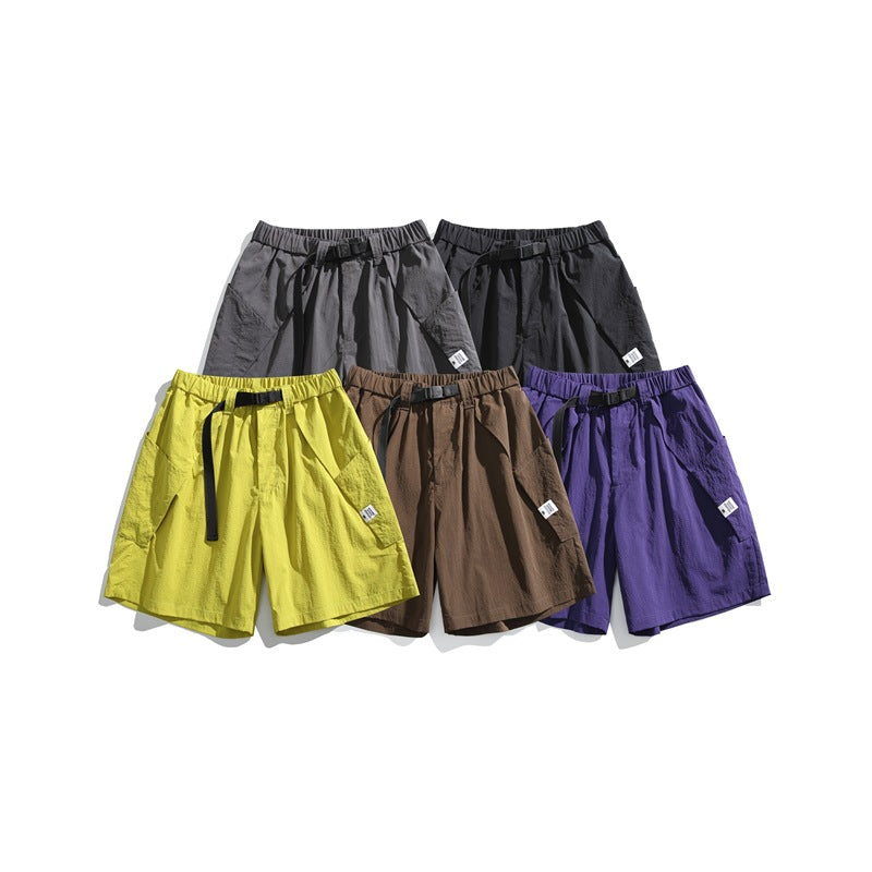 Five pairs of shorts arranged together in gray, black, yellow, brown, and purple.