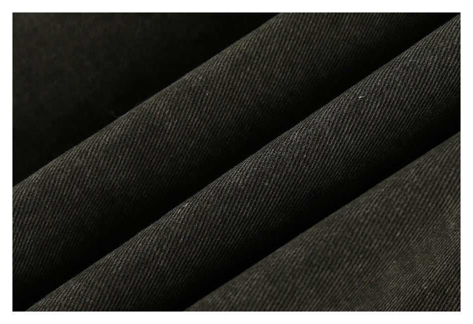Macro view of dark charcoal fabric showing a fine diagonal surface texture.