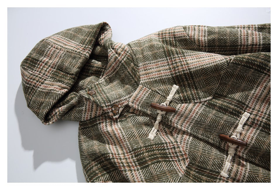 Angled close view of an olive, cream, and rust plaid hooded duffle coat with wooden toggle closures.