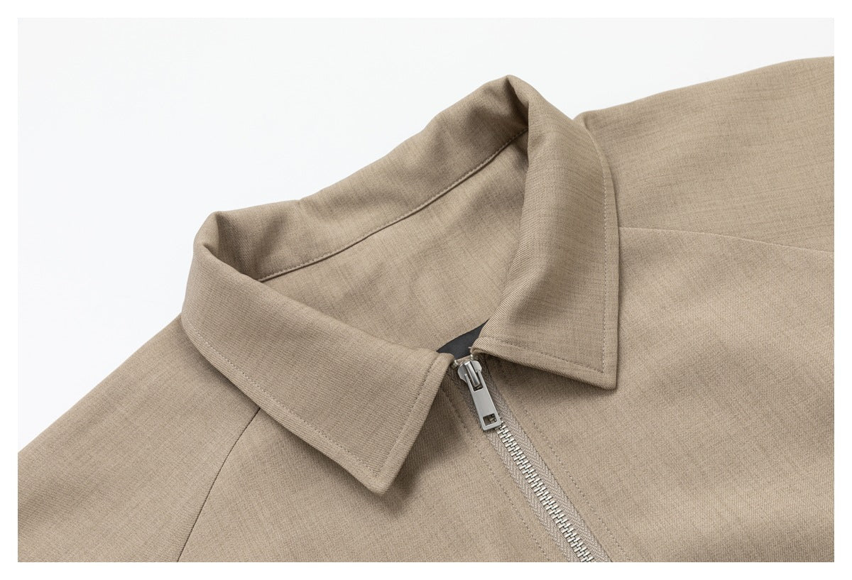 Close-up of the taupe jacket's pointed collar and silver front zipper.