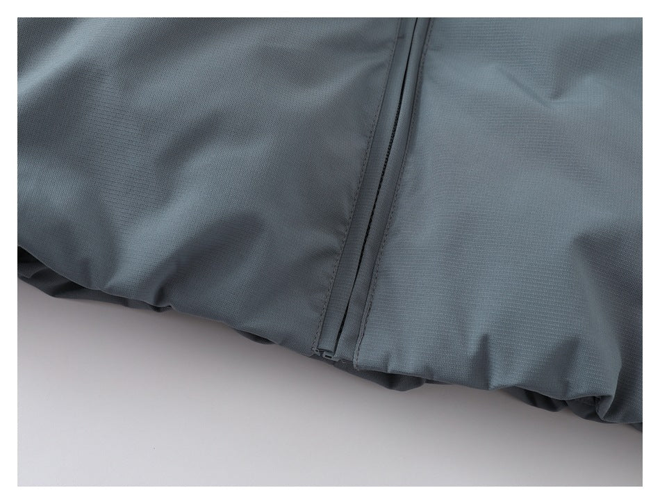 Close-up of the gray jacket's front zipper and lower hem.