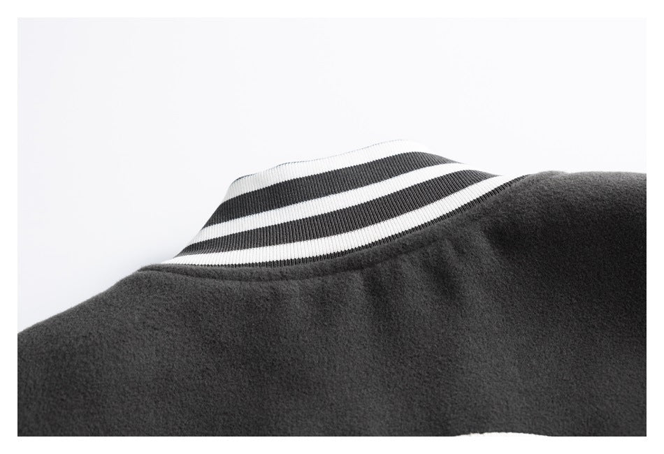 Close-up of a dark charcoal garment neckline with a ribbed white collar and two dark stripes.