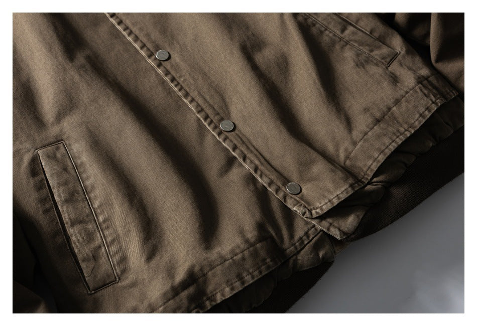 Cropped flat lay of a brown jacket front with snap buttons and welt pockets.