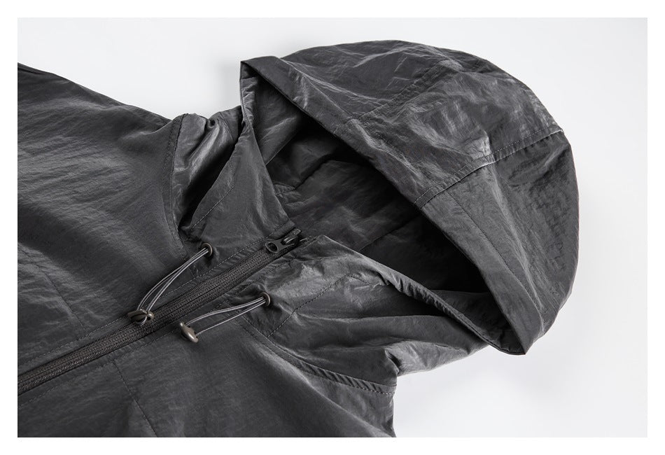 Close view of a charcoal gray hooded jacket front, showing the hood, zipper, and adjustable drawcords.