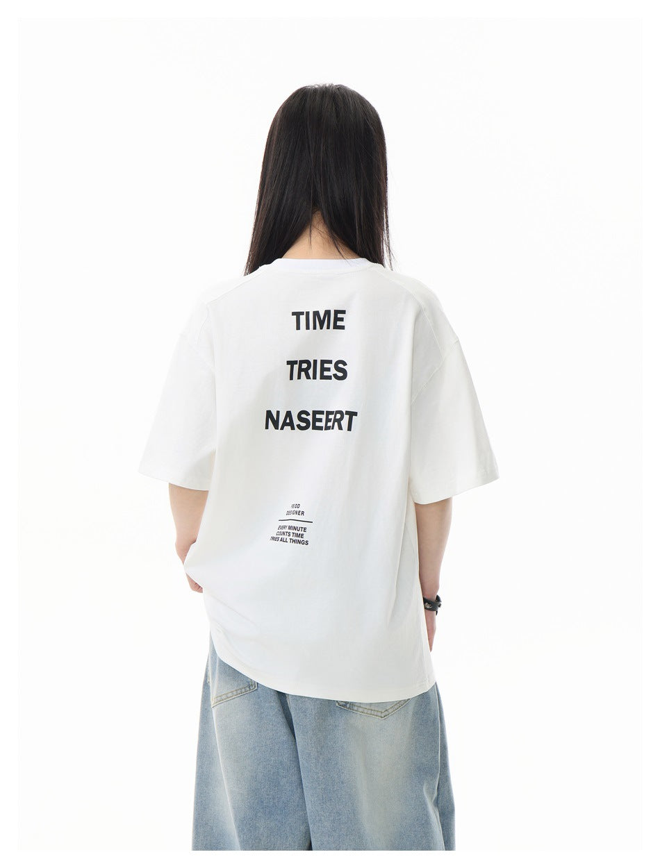 Back view of a model wearing a white oversized T-shirt with large stacked black text and smaller text below.