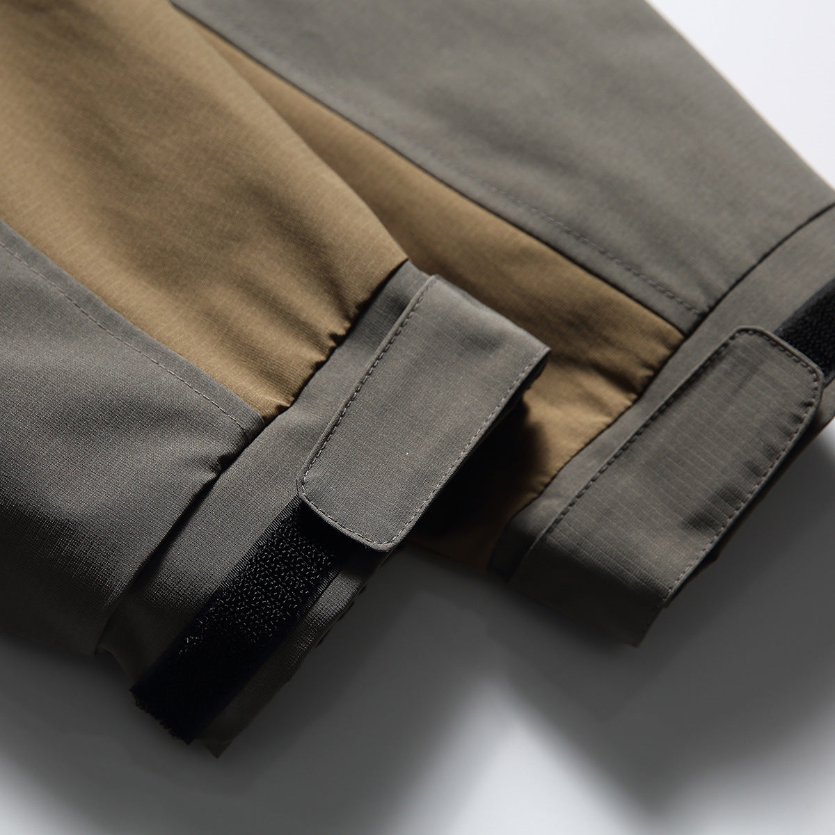 Close-up of gray-and-tan jacket sleeve ends with adjustable hook-and-loop cuffs.
