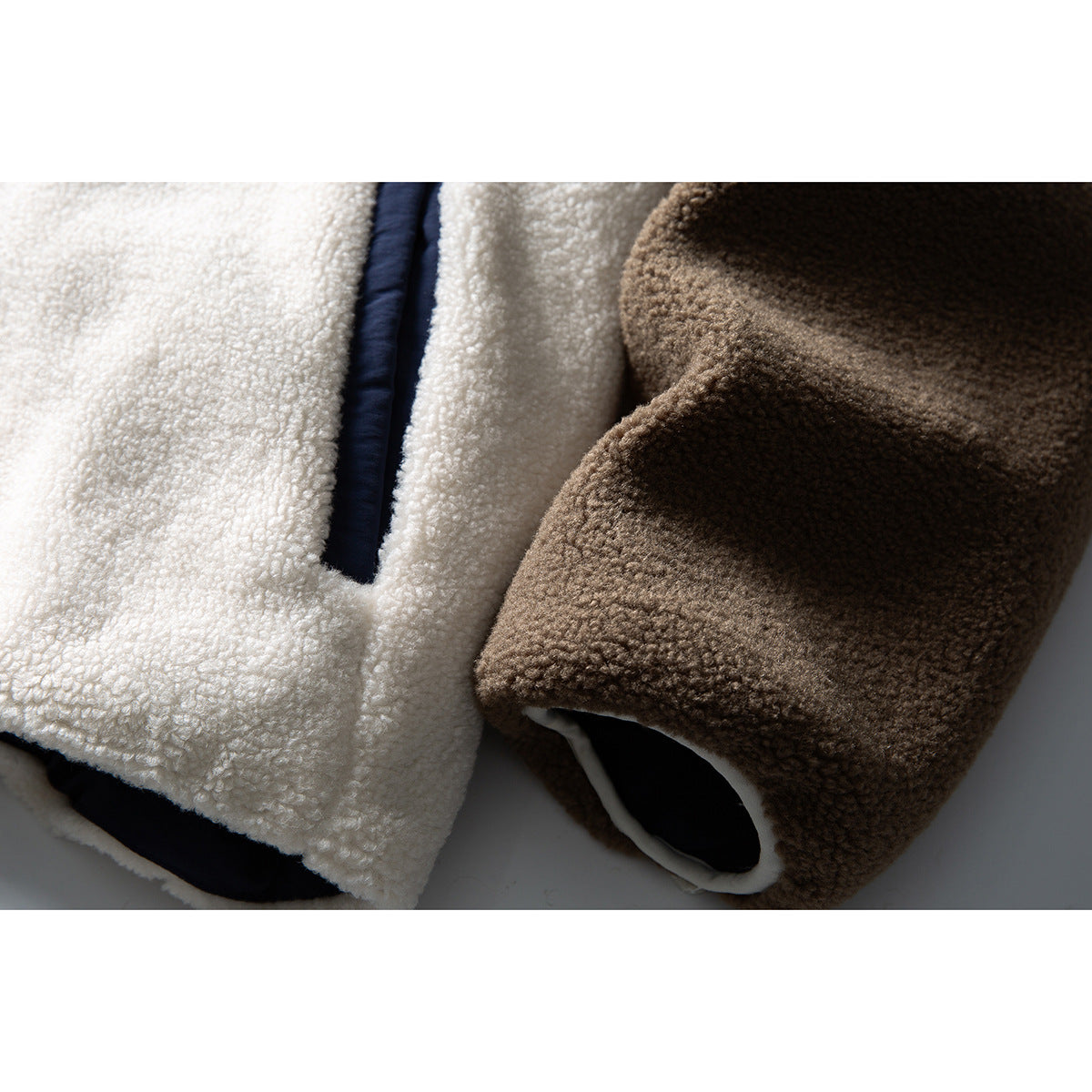 Close-up of cream and brown fleece jacket panels and sleeve cuffs with dark lining and navy trim.