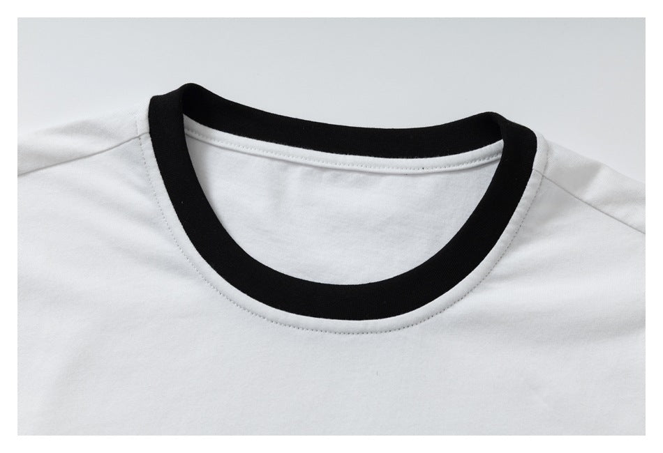Close-up of a white T-shirt’s black-trimmed round neckline and shoulder seams.