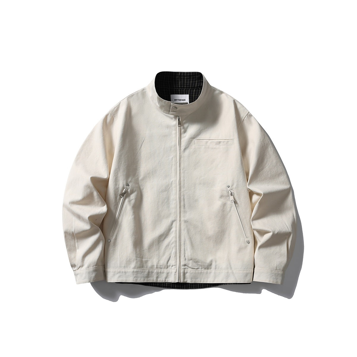 Off-white stand-collar zip-up jacket flat lay with zippered side pockets and black checked lining at the collar
