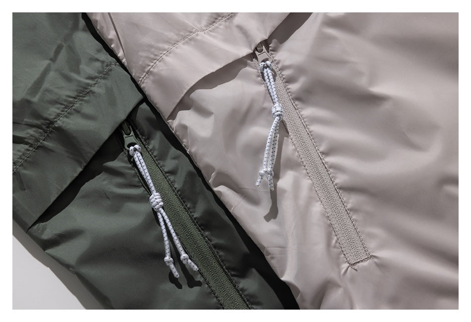 Close-up of taupe and dark olive garment panels with long zippers and cord pulls.