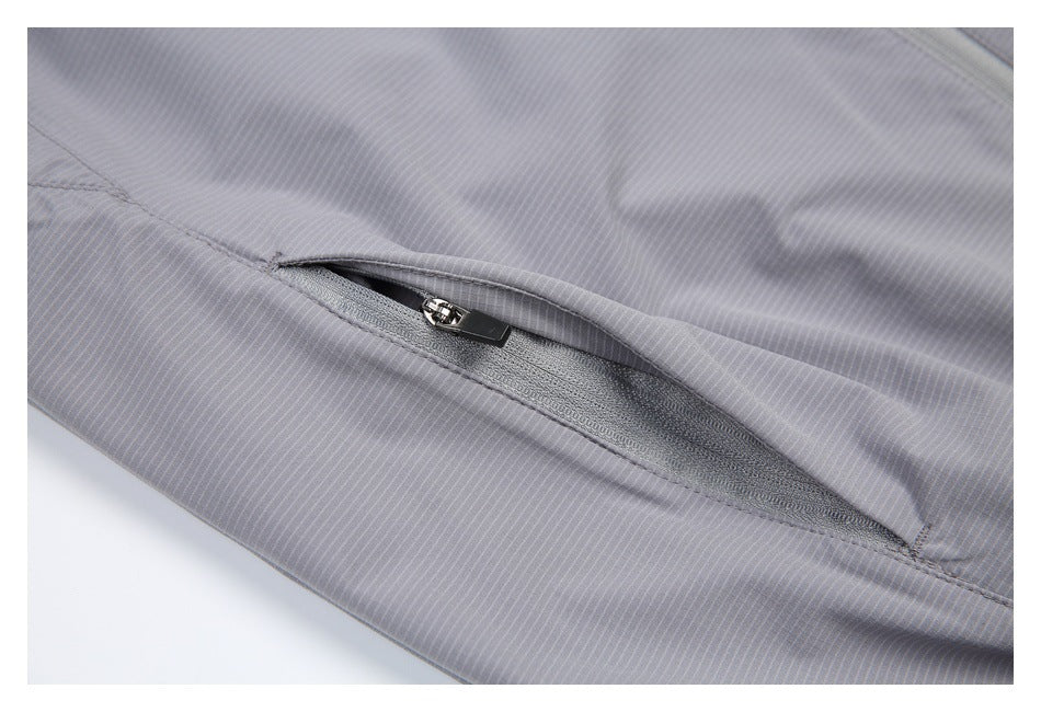 Close-up of an open angled zipper pocket on a light gray pinstriped garment.