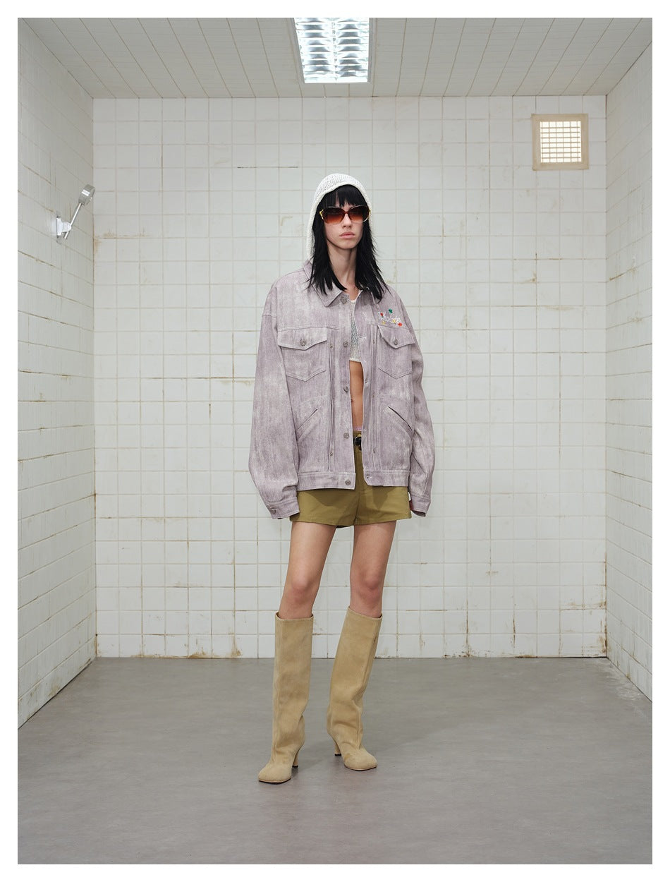 Model wearing the mauve-pink washed jacket open over a crop top with olive shorts and tan knee-high boots