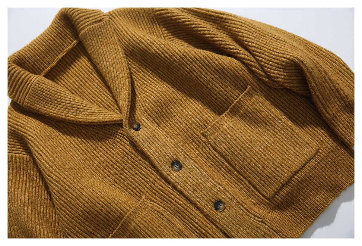 Mustard-brown ribbed cardigan laid flat, with a shawl collar, dark buttons, and patch pockets.