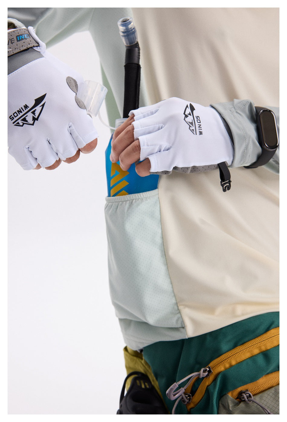 Close-up of the cycling top's pale blue side pocket as a gloved hand reaches for a bottle.