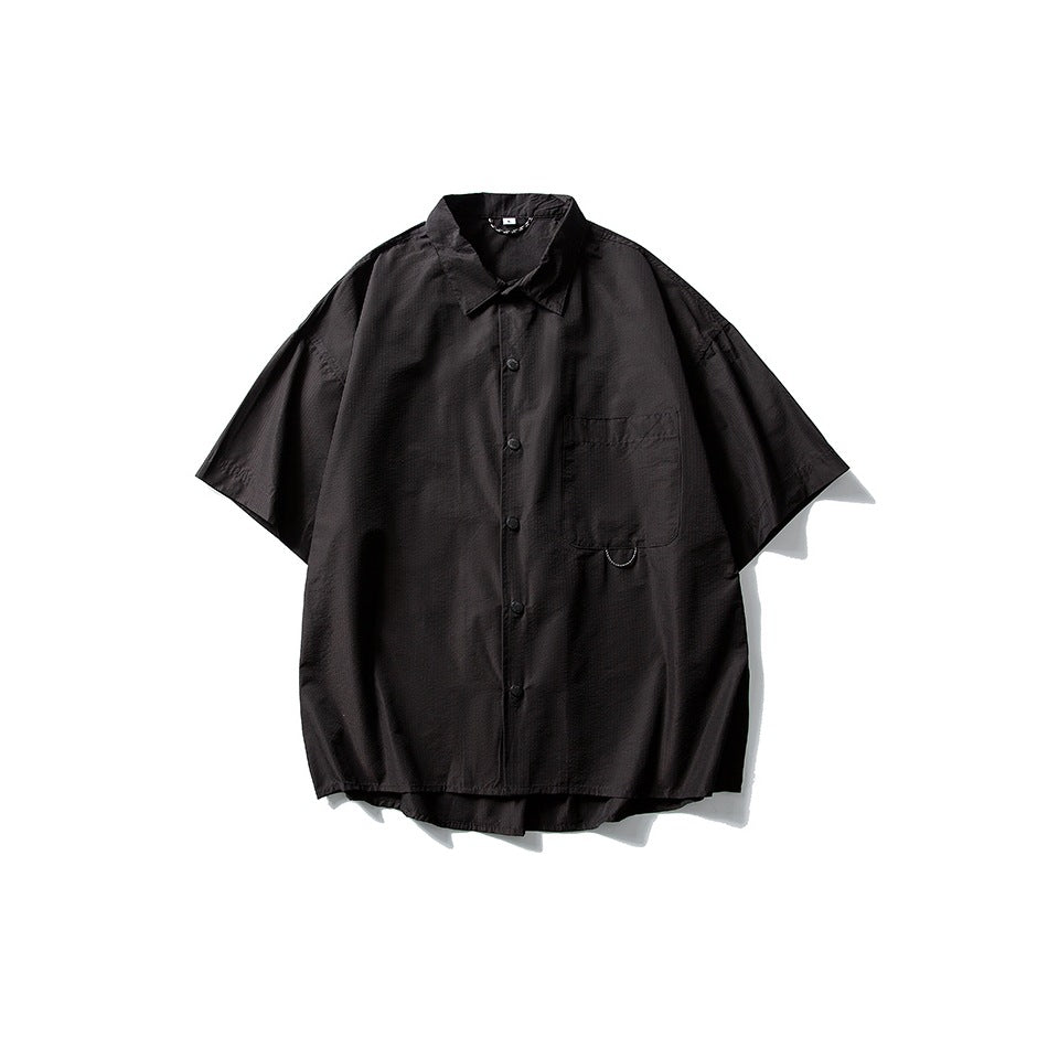 Black short-sleeve button-front shirt with collar and chest pocket, flat lay on white background