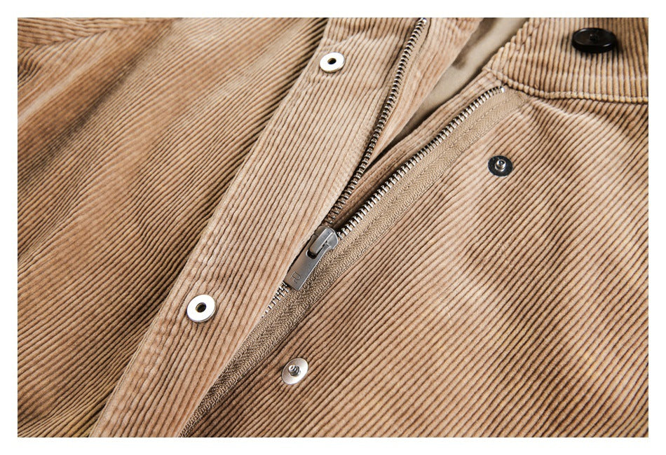 Close-up of a tan corduroy jacket's front zipper, snap fasteners, and button.