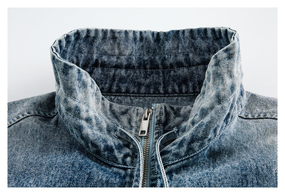 Close-up of the jacket's washed denim stand collar, front zipper and collar ties.