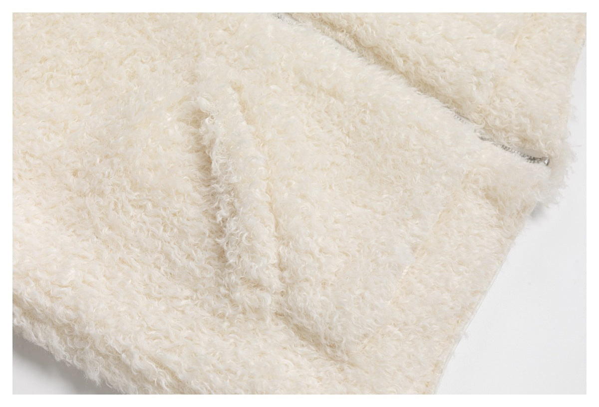 Close-up of cream curly pile with a zipper and folded garment seam.