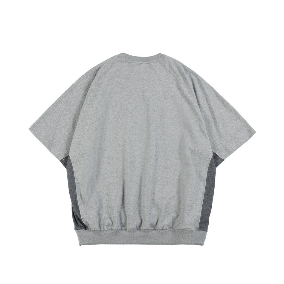 Back view of gray raglan short-sleeve top with darker gray side panels and ribbed crew neck and hem