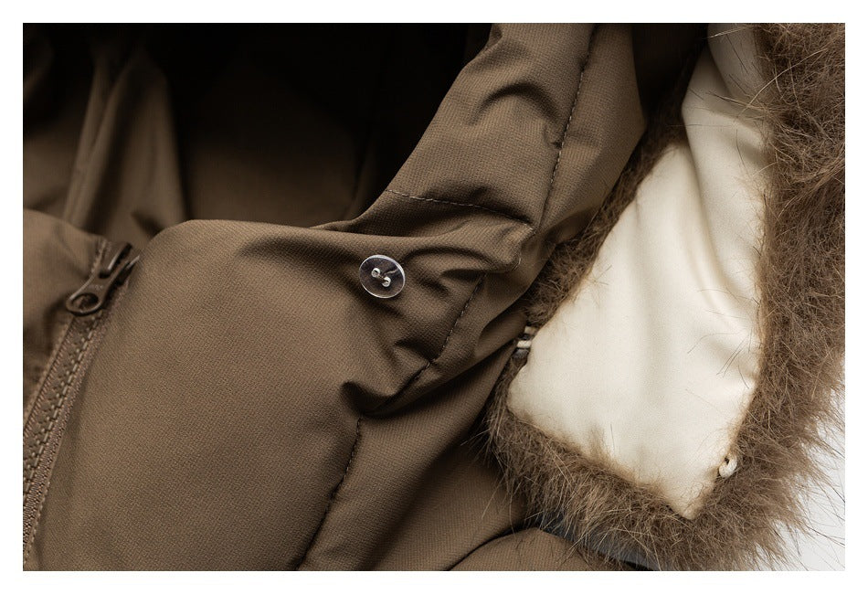 Close-up of a brown jacket sleeve with a button tab beside a light lining and fur trim.