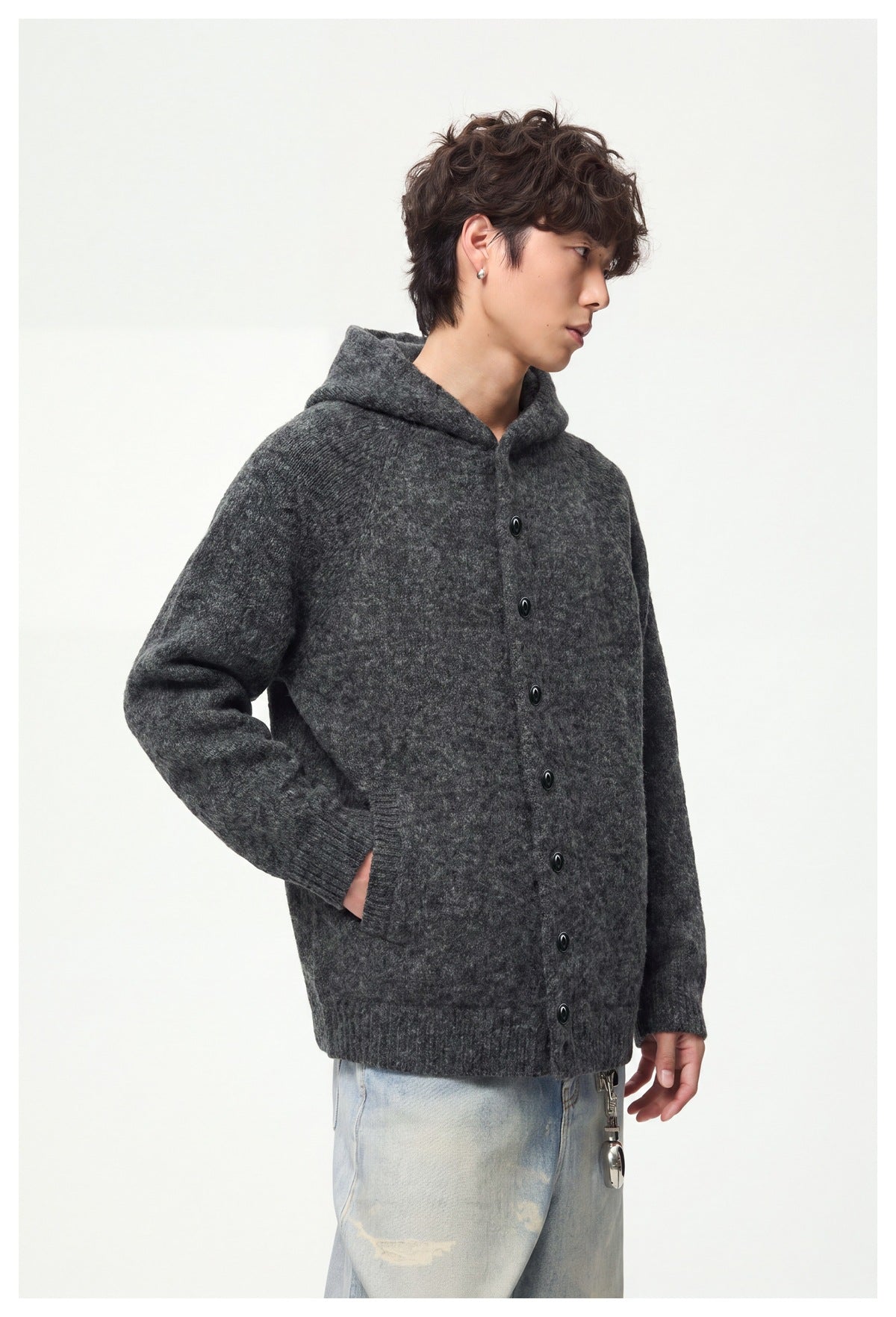 Side view of a model wearing a charcoal gray button-front hooded cardigan with a front pocket.