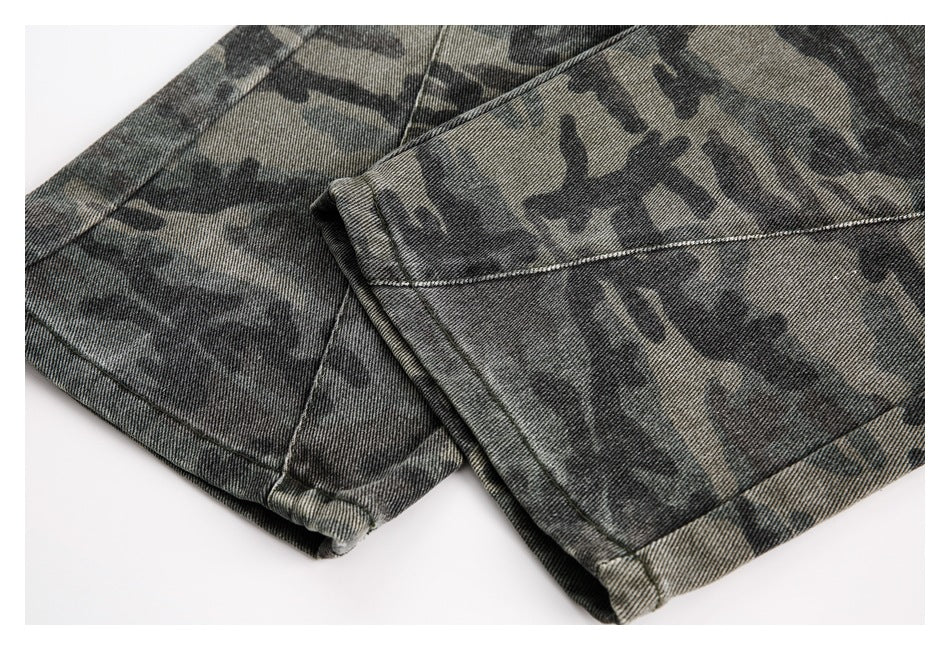 Close-up of overlapping hems on dark gray and olive camouflage trousers.