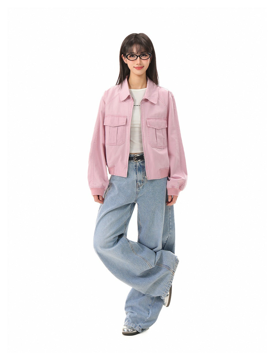 Model wearing pink cropped zip jacket with flap pockets, white top, black belt and wide-leg light blue jeans