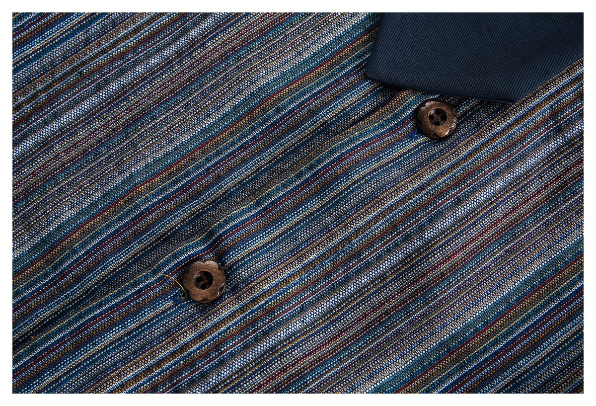 Close-up of two brown buttons and dark inner fabric against a fine multicolor-striped shirt.