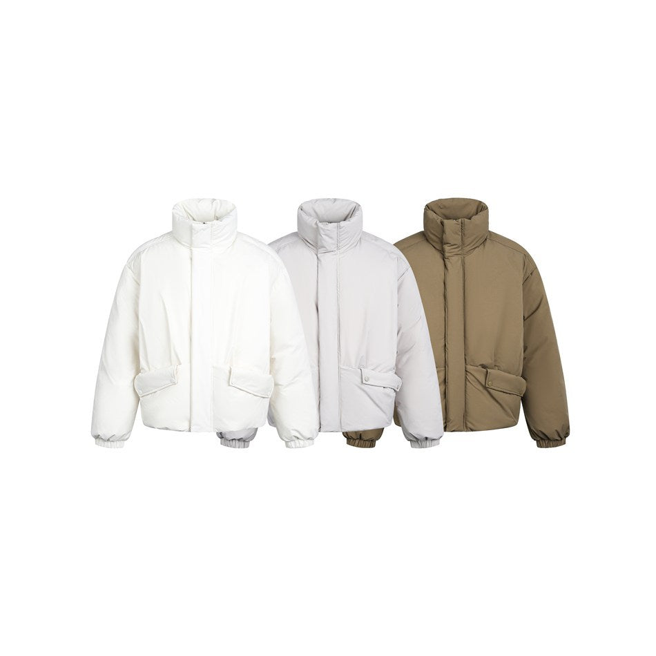 Three front-view puffer jackets with high collars and flap pockets in white, light gray, and taupe.