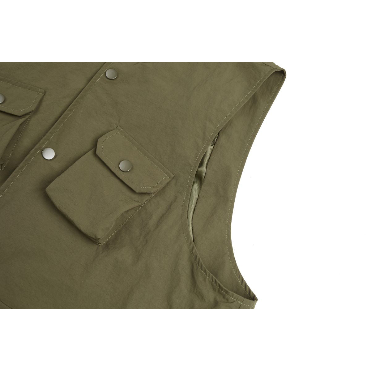 Close-up of an olive vest's flap pocket, snap buttons, stitching, and armhole.