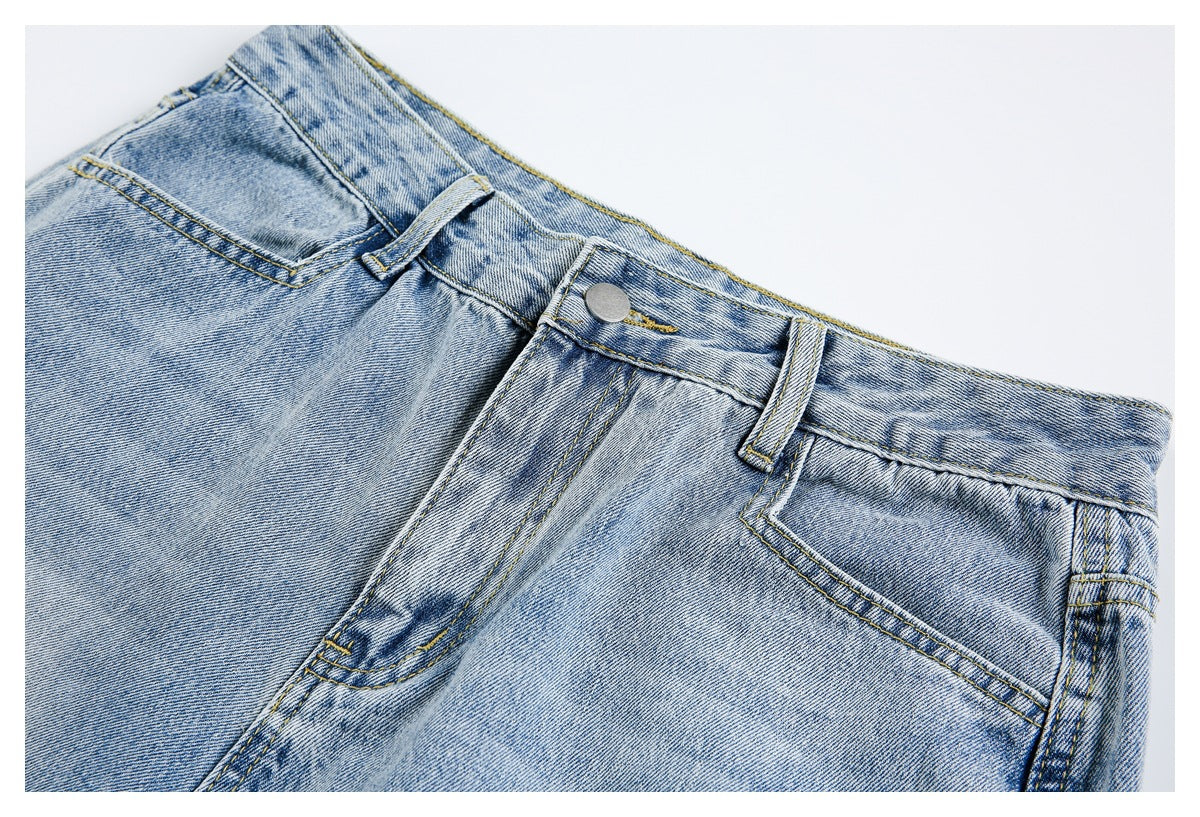 Close view of light-wash jeans showing the front button, fly, belt loops and pockets.
