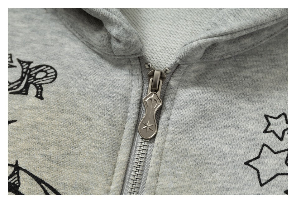 Close-up of the gray hoodie’s metal zipper and star-shaped pull, with black printed graphics nearby.