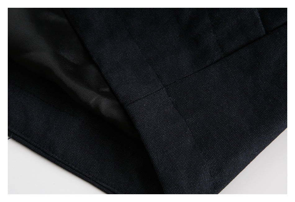 Close-up of dark navy garment fabric, lining, and a stitched edge.
