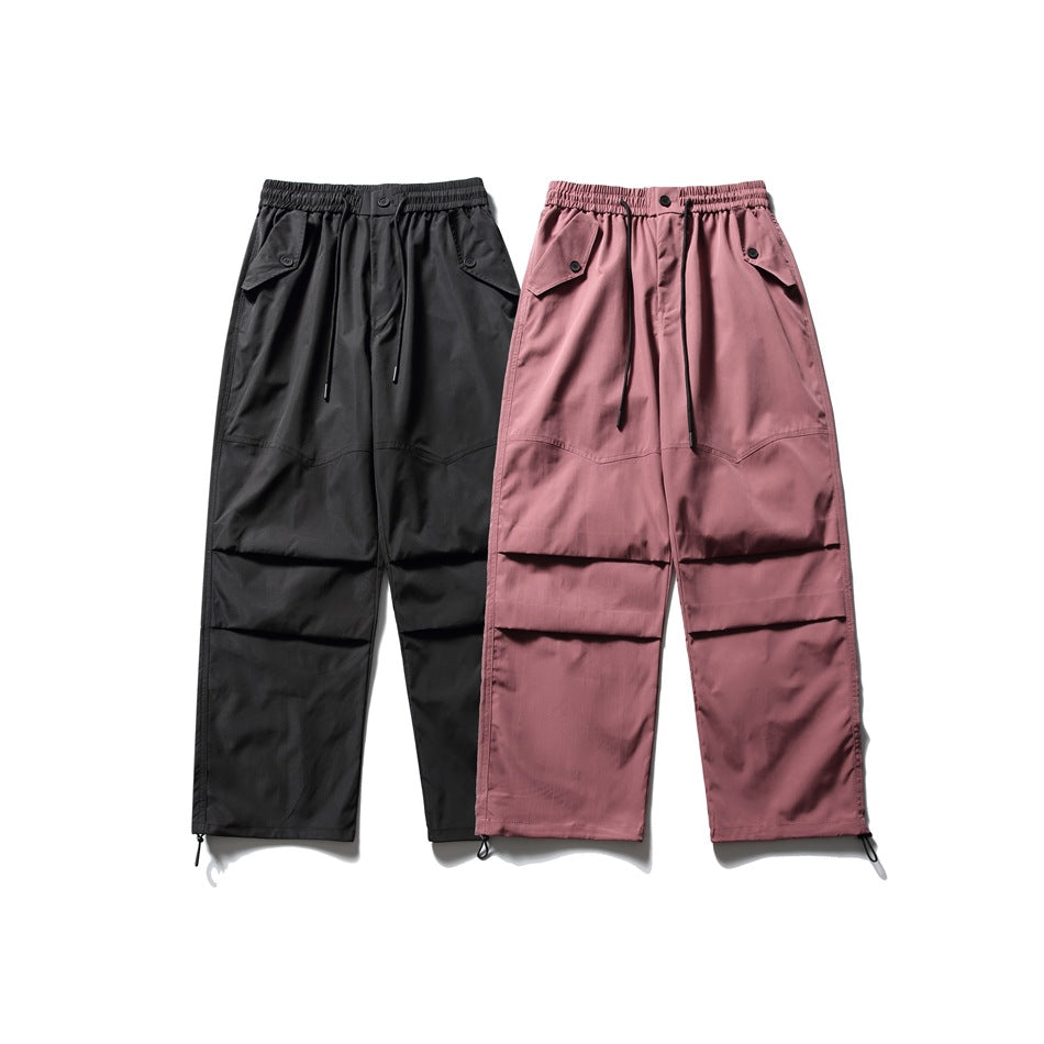 Two pairs of loose cargo pants shown flat: black and mauve, both with elastic drawstring waists and layered leg pockets.