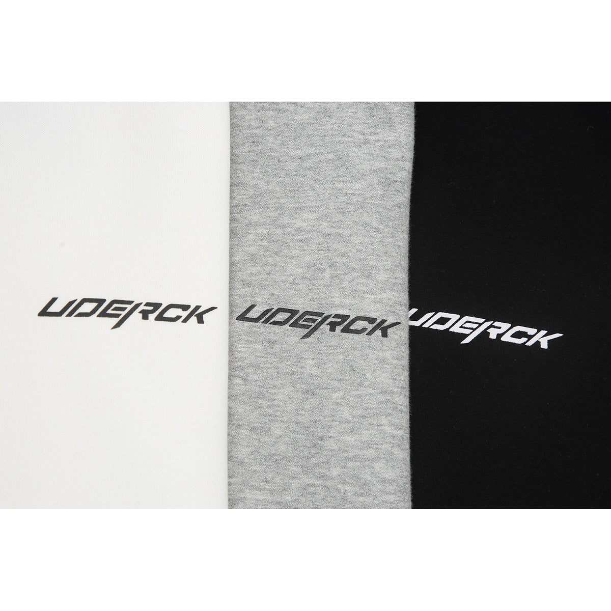 Close-up of white, heather-gray, and black fabric panels, each with a stylized logo print.