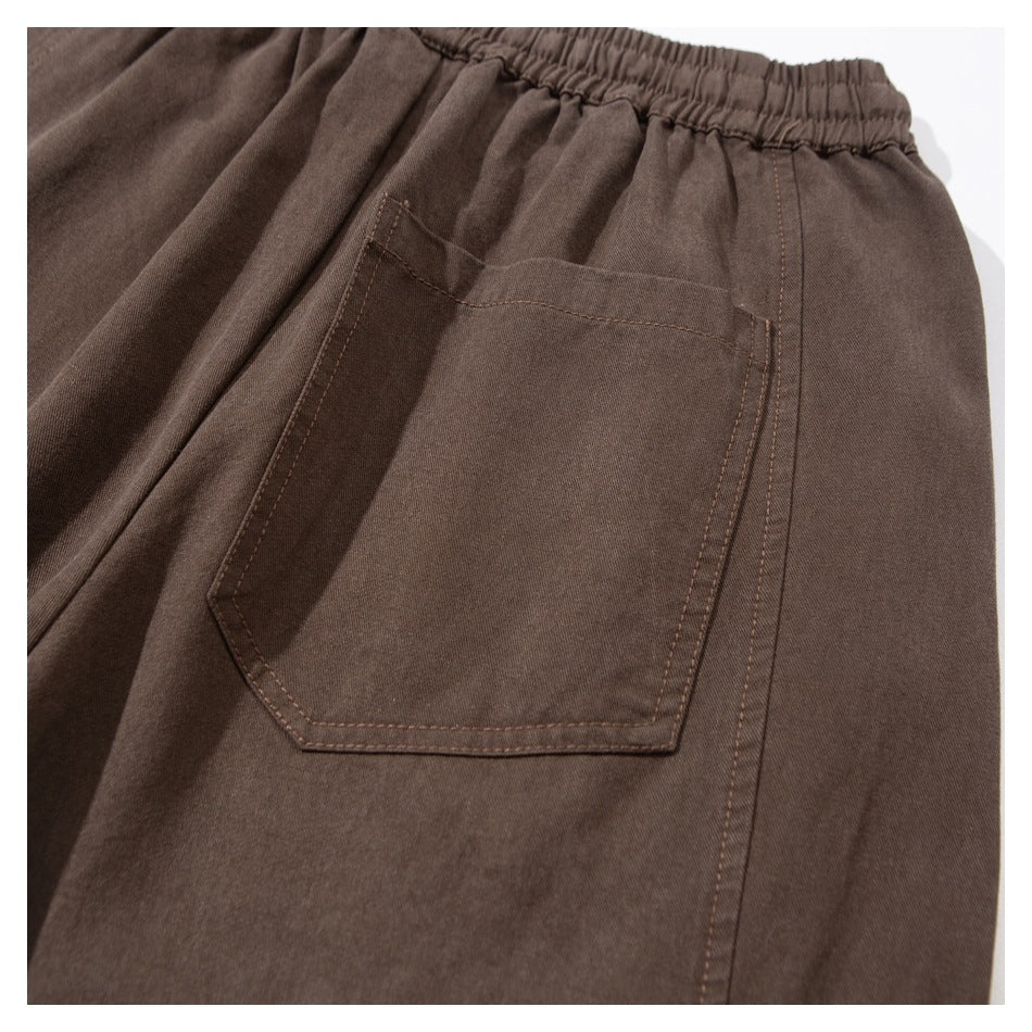 Close-up of a brown pants pocket with contrast stitching and an elastic waistband.