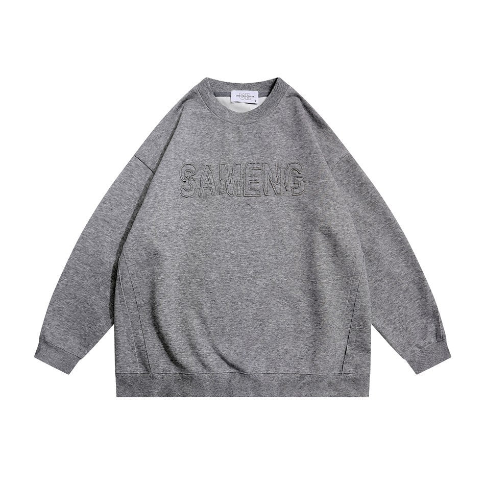Dark gray crew-neck sweatshirt flat lay with raised stitched outline lettering on the chest and ribbed trim