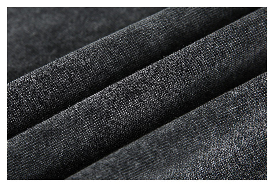 Macro view of dark charcoal fabric arranged in soft folds, showing its fine textured surface.