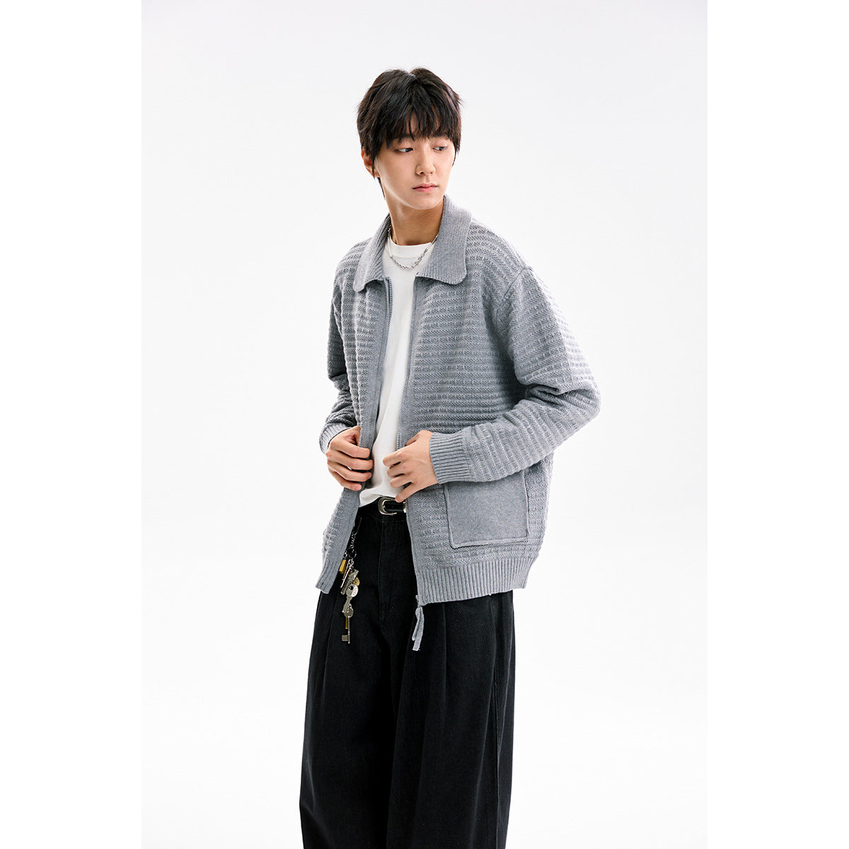 Closer view of a model wearing a light gray textured cardigan with a collared neckline and front pockets.